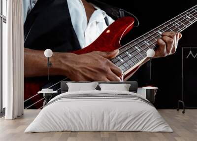 African American handsome jazz musician playing bass guitar in the studio on a black background. Music concept. Young joyful attractive guy improvising. Close-up retro portrait. Wall mural