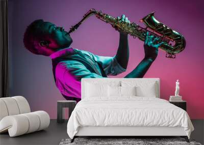 African American handsome jazz musician playing the saxophone in the studio on a neon background. Music concept. Young joyful attractive guy improvising. Close-up retro portrait. Wall mural