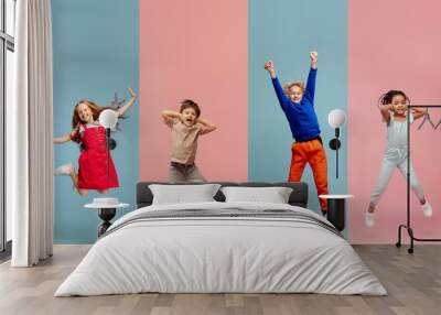 Art collage made of portraits of little and happy kids isolated on multicolored studio background. Human emotions, facial expression concept Wall mural