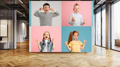 Art collage made of portraits of little and happy kids isolated on multicolored studio background. Human emotions, facial expression concept Wall mural