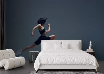 Athletic art. Dynamic image of sportive woman in motion, jumping, running, training against grey studio background. Concept of sportive lifestyle, beauty, body care, fitness, health Wall mural