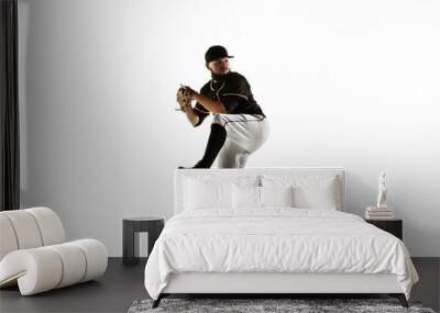 Baseball player, pitcher in a black uniform practicing and training isolated on a white background. Young professional sportsman in action and motion. Healthy lifestyle, sport, movement concept. Wall mural