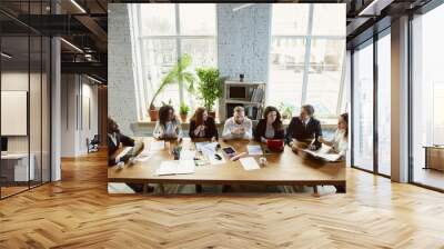 Best team. Group of young business professionals having a meeting. Diverse group of coworkers discuss new decisions, plans, results, strategy. Creativity, workplace, business, finance, teamwork. Wall mural