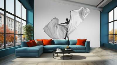 black and white portrait of graceful ballerina dancing with fabric, cloth isolated on grey studio ba Wall mural