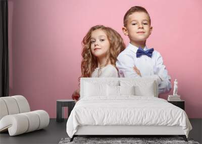 Boy and girl standing in studio on pink background Wall mural