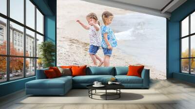 Children on the sea beach. Twins going along sea water. Wall mural