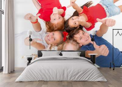 Close-up of happy children lying on floor in studio and looking up, isolated on white background, top view. Kids emotions and fashion concept Wall mural