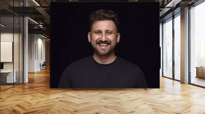 Close up portrait of young man isolated on black studio background. Photoshot of real emotions of male model. Smiling, feeling crazy happy, laughting. Facial expression, human emotions concept. Wall mural