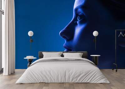 Closeup profile view of young pretty girl with well-kept skin isolated over dark blue background in neon light. Concept of art, fashion, style, inspiration Wall mural