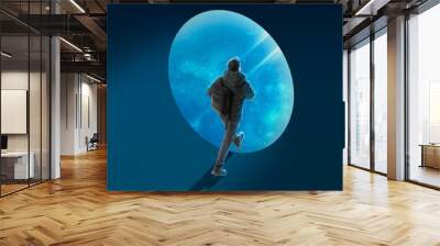 Conceptual creative artwork with young man walking on outer space background. Concept of astronautics, dreams, astronomy, art, Day of Human Space Flight Wall mural