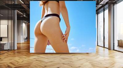 Cropped image of sportive fit female body in swimsuit, girl playing intense frisbee game with friends on beach. Concept of sport, summer activity, leisure games, friendship Wall mural