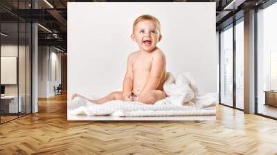 Cute, adorable baby, child in calmly sitting in towel and smilling against white studio background. After shower. Concept of childhood, newborn lifestyle, happiness, care. Copy space for ad Wall mural