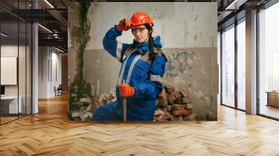 Destroying gender stereotypes. Woman wearing helmet using different male work tools. Gender equality. Girl working at flat remodeling. Building, repair and renovation. woman in the male profession Wall mural