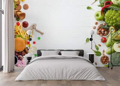 Fast and healthy food compared on white background. Unhealthy set of burgers, sauces, french fries in comparison with set of vegetables, fruits, organic green avocado, cabbage, nuts, citruses. Wall mural