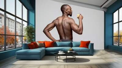 Fit young man with beautiful torso, isolated on white background. The naked torso of African American man posing at studio. The muscular body, fitness, sports, healthy lifestyle and bodybuilder Wall mural