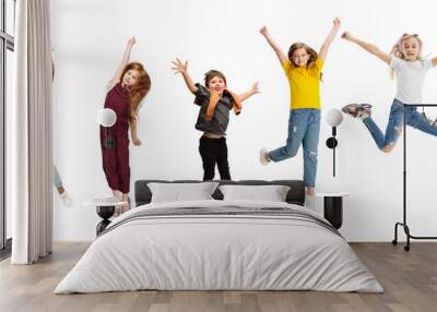 Five school kids or pupils jumping in colorful casual clothes isolated on white studio background. Creative collage. Wall mural