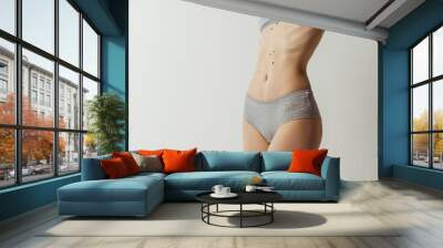 Flat belly. Beautiful body of young caucasian woman isolated on gray studio background. Natural beauty concept Wall mural