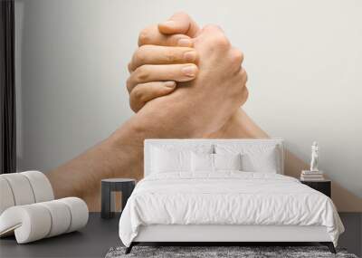 Friends greetings sign or disagreement. Two male hands competion in arm wrestling isolated on grey studio background. Concept of standoff, support, friendship, business, community, strained relations. Wall mural