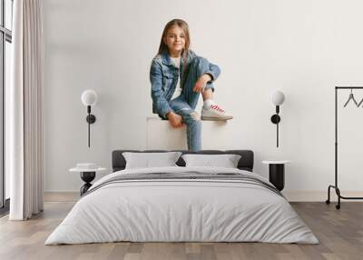 full length portrait of cute little teen girl in stylish jeans clothes looking at camera and smiling Wall mural