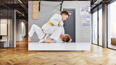 Future sportsmen. Boys, children in white kimono training, practising judo, jiu-jitsu exercises indoors. Concept of martial arts, combat sport, sport education, childhood, hobby Wall mural