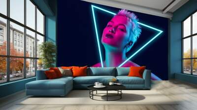 Future. Portrait of female fashion model in neon light with neoned blue glowing triangle on dark studio background. Beautiful woman with trendy make-up and well-kept skin. Vivid style, beauty concept. Wall mural