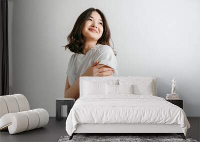 Happy asian woman standing and smiling isolated on gray studio background. Beautiful female half-length portrait. Young emotional woman. The human emotions, facial expression concept. Wall mural