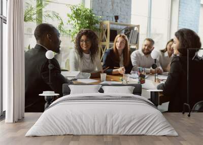 Happy emotions. Group of young business professionals having a meeting. Diverse group of coworkers discuss new decisions, plans, results, strategy. Creativity, workplace, business, finance, teamwork. Wall mural