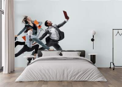 Happy office workers jumping and dancing in casual clothes or suit with folders isolated on studio background. Business, start-up, working open-space, motion and action concept. Creative collage. Wall mural