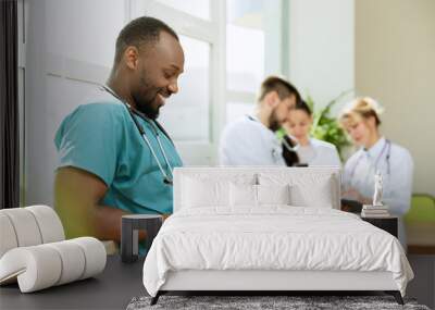 Healthcare people group. Professional african american male doctor with phone posing at hospital office or clinic. Medical technology research institute and doctor staff service concept. Happy smiling Wall mural