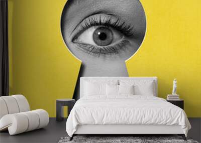 hidden secrets. female eye attentively looking into keyhole against yellow background. contemporary  Wall mural