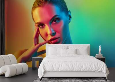 High Fashion model woman in colorful bright lights posing in studio Wall mural