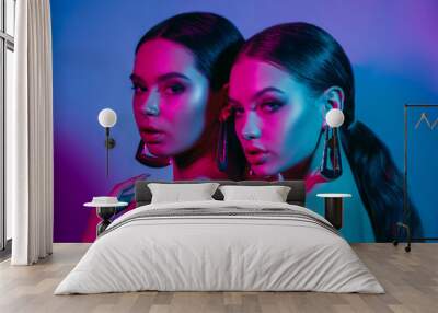 High fashion models in colorful bright neon lights posing at studio. Portrait of beautiful girls with trendy glowing make-up. Art design vivid style. Wall mural