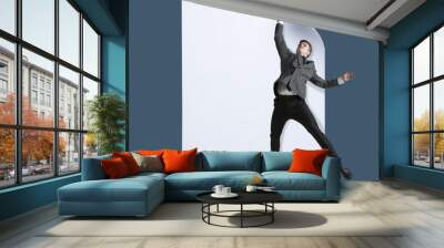 Imagine who's covering white sheet to get digital file icon. Office style young man catching the edge of huge paper sheet. Digital world, funny imagination of the way the icon's appearing. Wall mural