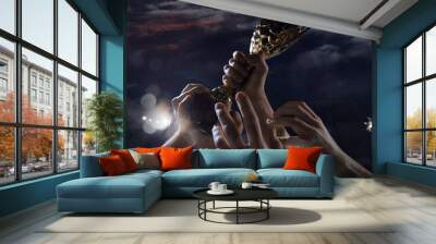 Leader way. Award of victory, male hands tightening the golden cup of winners against cloudy dark sky. Sport, competition, championship, winning, achieving the goal. Prize for success and honor. Wall mural