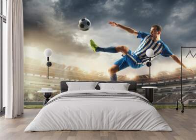 Male football or soccer player at stadium in flashlight. Young male sportive model training. Moment of attacking, catching. Concept of sport, competition, winning, action, motion, overcoming. Flyer. Wall mural