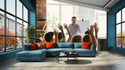 Male speaker giving presentation in hall at university workshop. Audience or conference hall. Rear view of unrecognized participants in audience. Scientific conference event, training. Education Wall mural