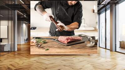 Man cooking meat steak on kitchen Wall mural