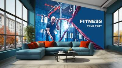 Men with battle rope battle ropes exercise in the fitness gym. CrossFit concept. gym, sport, rope, training, athlete, workout, exercises concept Wall mural