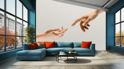 Moment of weightless. Two male hands trying to touch like a creation of Adam sign isolated on grey studio background. Concept of human relation, community, togetherness, symbolism, culture and history Wall mural