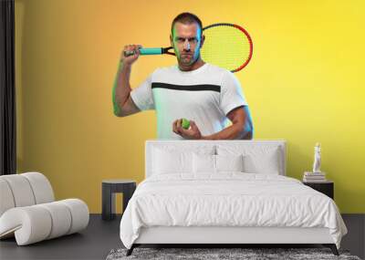 One caucasian man playing tennis isolated on studio background in neon light. Fit young professional male player in motion or action during sport game. Concept of movement, sport, healthy lifestyle. Wall mural