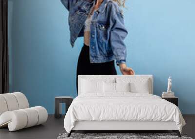 Portrait of attractive young girl in retro 90s fashion style, outfits posing isolated over blue studio background. Concept of eras comparison, beauty, fashion and youth. Wall mural