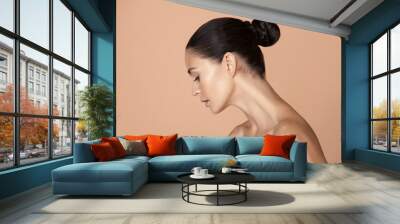 Portrait of beautiful young woman isolated on brown studio background. Caucasian female model looking at side confident. Concept of women's health and beauty, self-care, body, skin care, treatment. Wall mural