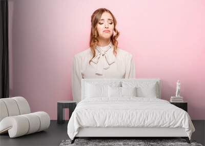 Portrait of displeased upset female frowns face as going to cry, being discontent and unhappy as cant achieve goals, isolated over pink studio background. Dissapointed young woman has troubles Wall mural