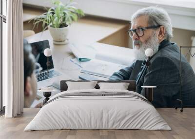 Portrait of elderly gray-headed man, professor, teacher checking up students homework at classroom, indoors. Concept of professional occupation, job, education Wall mural