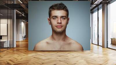 Portrait of shirtless young man isolated on grey studio background. Caucasian healthy male model looking at camera and posing. Concept of men's health and beauty, self-care, body and skin care. Wall mural