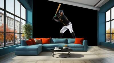 Professional baseball player, pitcher in sports uniform and equipment practicing isolated on a black studio background. Team sport concept Wall mural