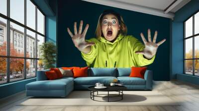 Pushing away. Portrait of young crazy scared and shocked caucasian woman isolated on dark background. Copyspace for ad. Bright facial expression, human emotions concept. Looking horror on TV, cinema. Wall mural