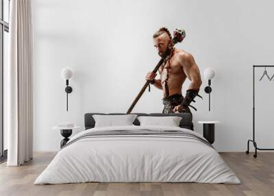 Serious long hair and muscular male model in leather viking's costume with the big mace cosplaying isolated on white studio background. Half-length portrait. Fantasy warrior, antique battle concept. Wall mural