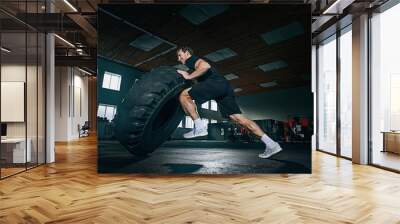 Shirtless young fit man flipping heavy tire at gym. The exercise, fitness, sport, workout, athlete, power, training, bodybuilding concept Wall mural