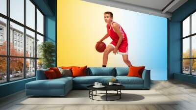 Strategy. Full length portrait of young basketball player in uniform on gradient studio background. Teenager confident posing with ball. Concept of sport, movement, healthy lifestyle, ad, action Wall mural